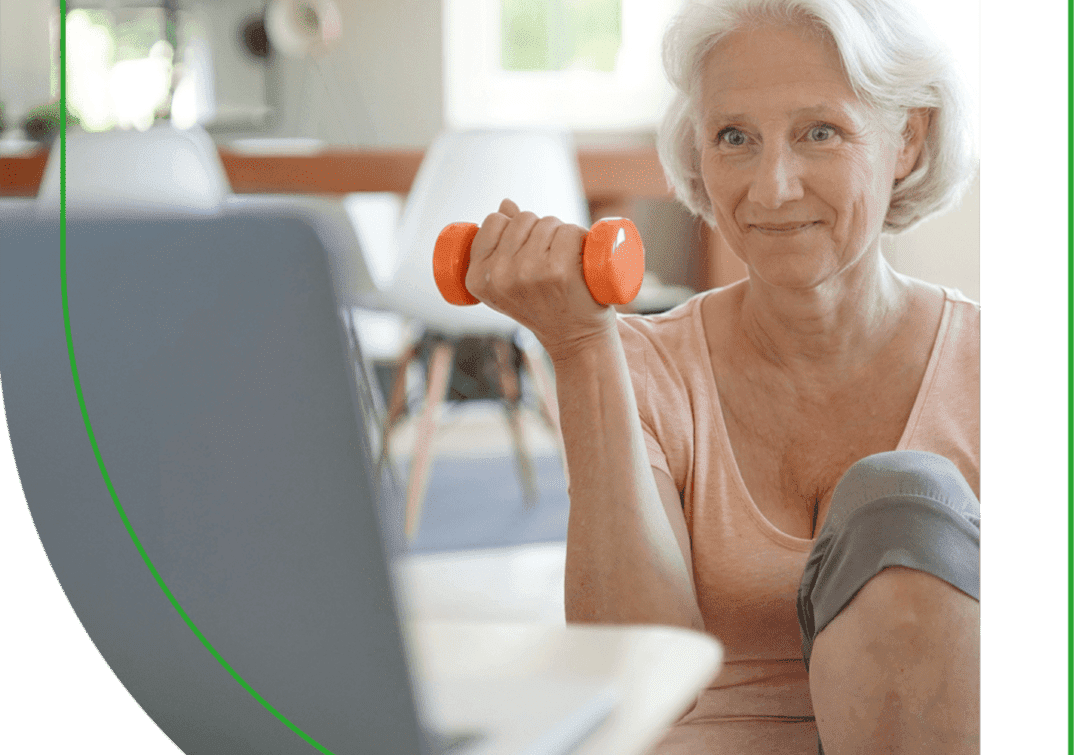 A woman holding a dumbbell in front of her laptop.