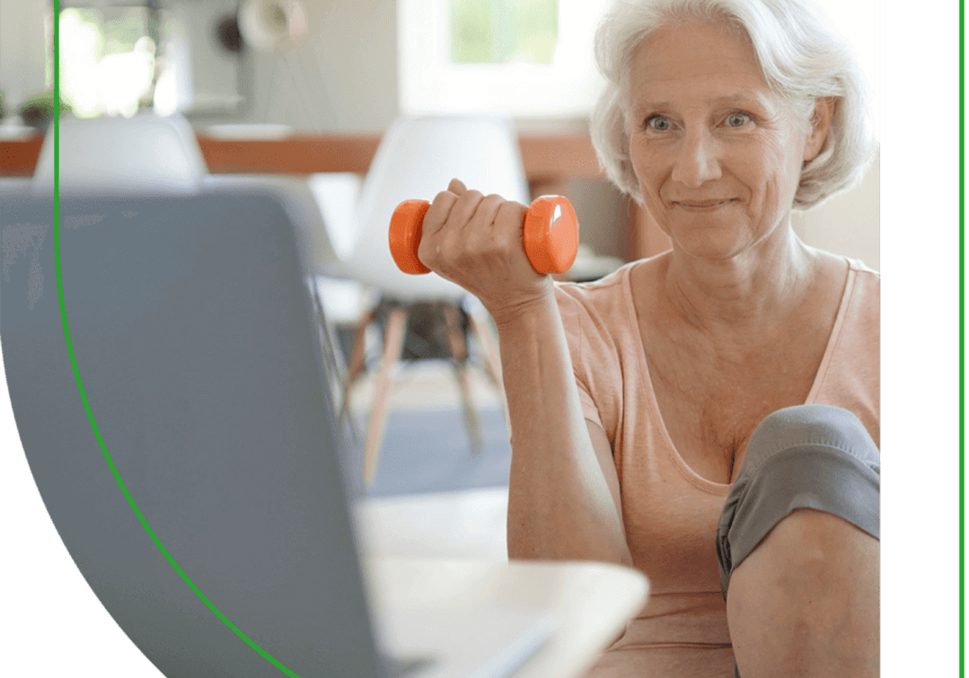 A woman holding a dumbbell in front of her laptop.